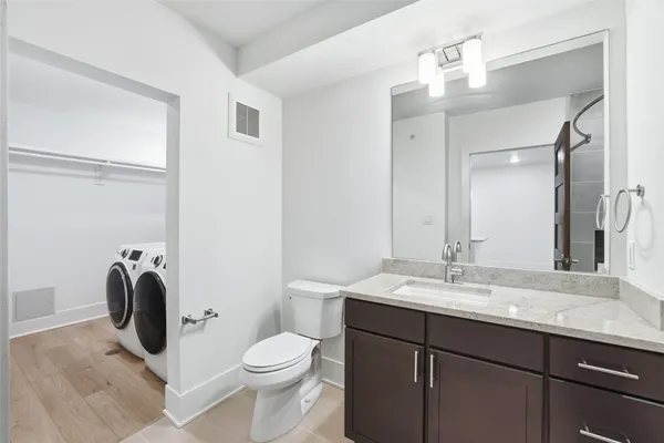 a bathroom with a sink vanity granite toilet and a mirror