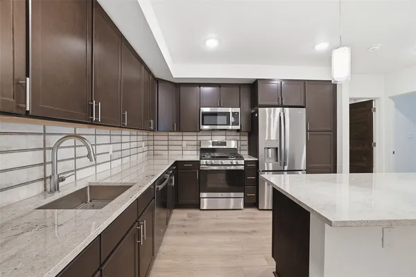 a kitchen with stainless steel appliances granite countertop a sink stove and refrigerator