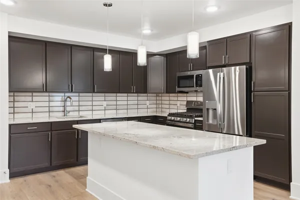 a kitchen with stainless steel appliances a sink stove and refrigerator