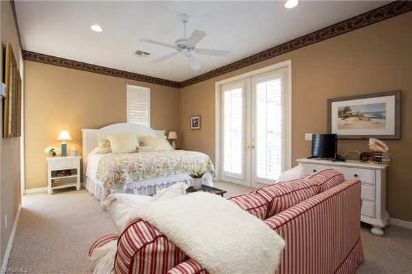 a bedroom with a large bed and a chandelier