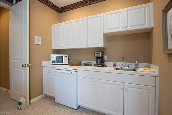 a kitchen with white cabinets and sink