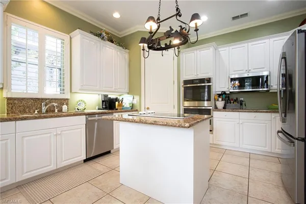 a kitchen with stainless steel appliances granite countertop a stove top oven a refrigerator a sink and dishwasher