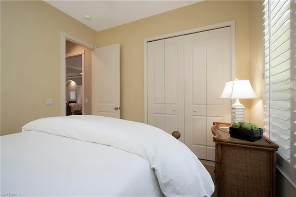 a bedroom with a bed and a lamp on the dresser