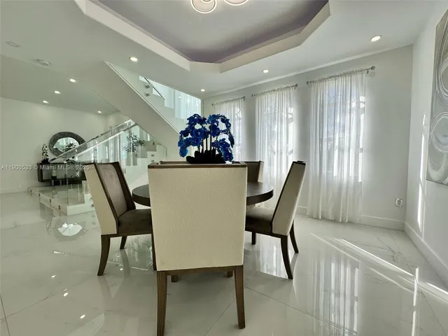 a large kitchen with kitchen island a white counter top stainless steel appliances and cabinets