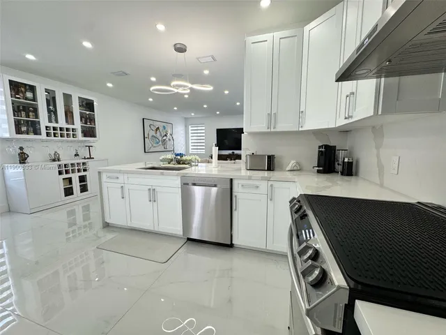 a kitchen with granite countertop a sink a stove and cabinets