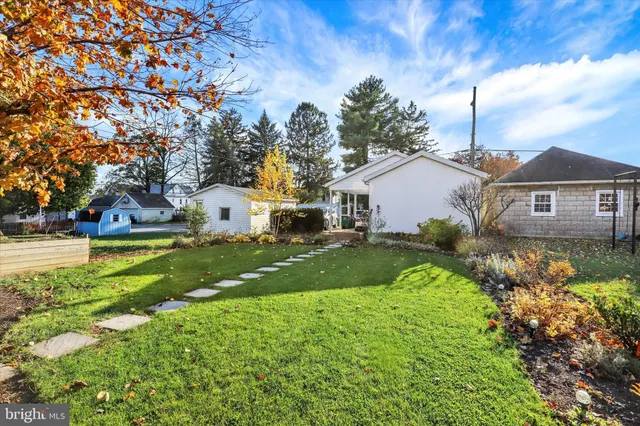 a view of a house with a big yard and large trees