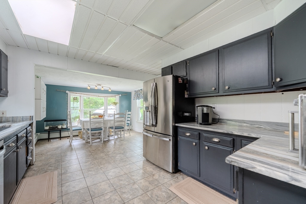 29 3rd Street Ayer, MA 01432 - Photo 8 of 29 a kitchen with granite countertop a refrigerator and a stove top oven