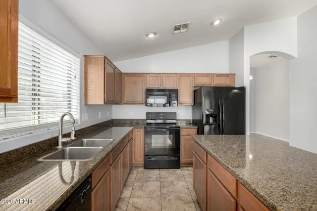 a kitchen with granite countertop stainless steel appliances window a sink and a counter space