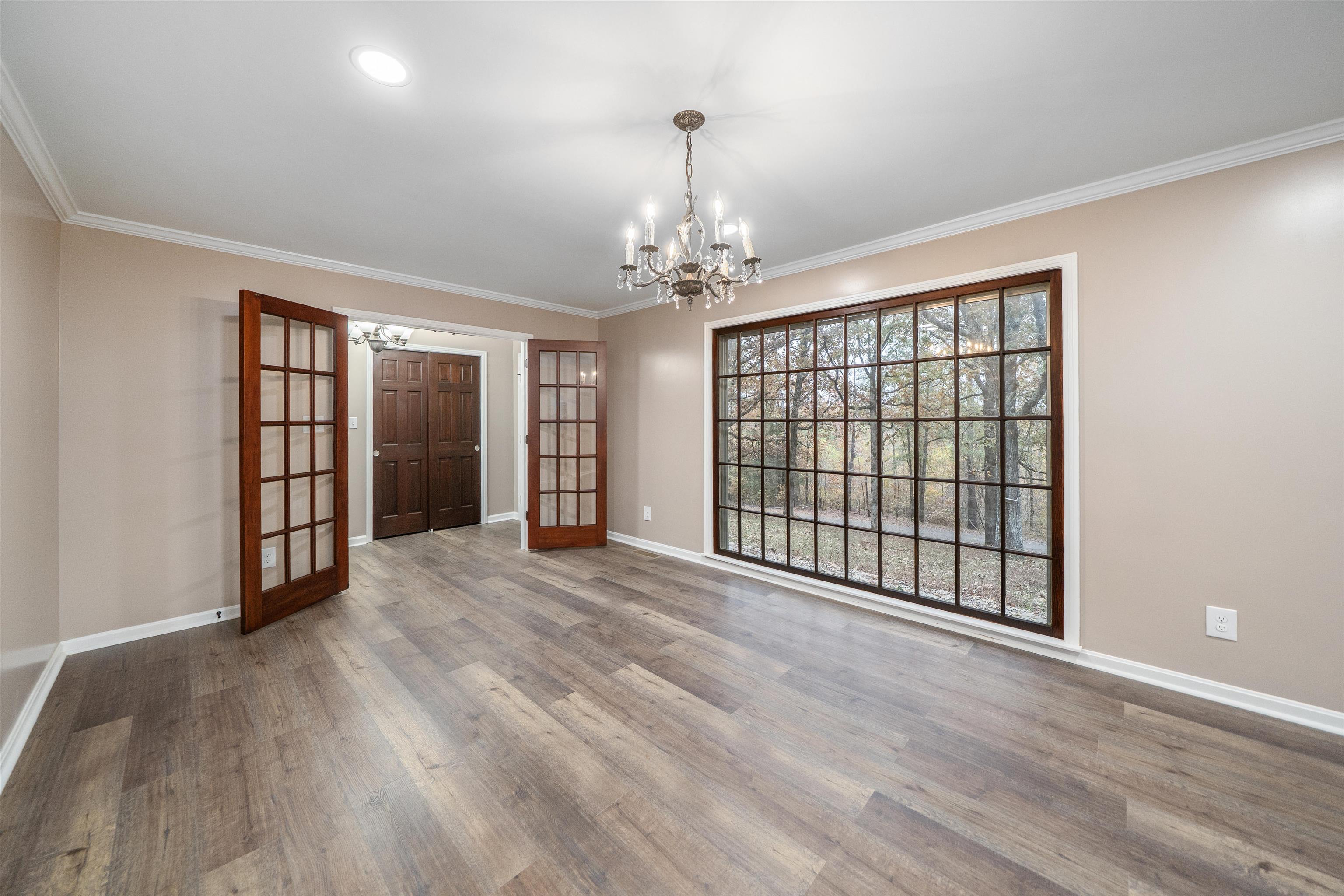 567 South 6th Street Selmer, TN 38375 - Photo 14 of 31 Spare room featuring a chandelier, ornamental molding, light wood-style floors, and french doors
