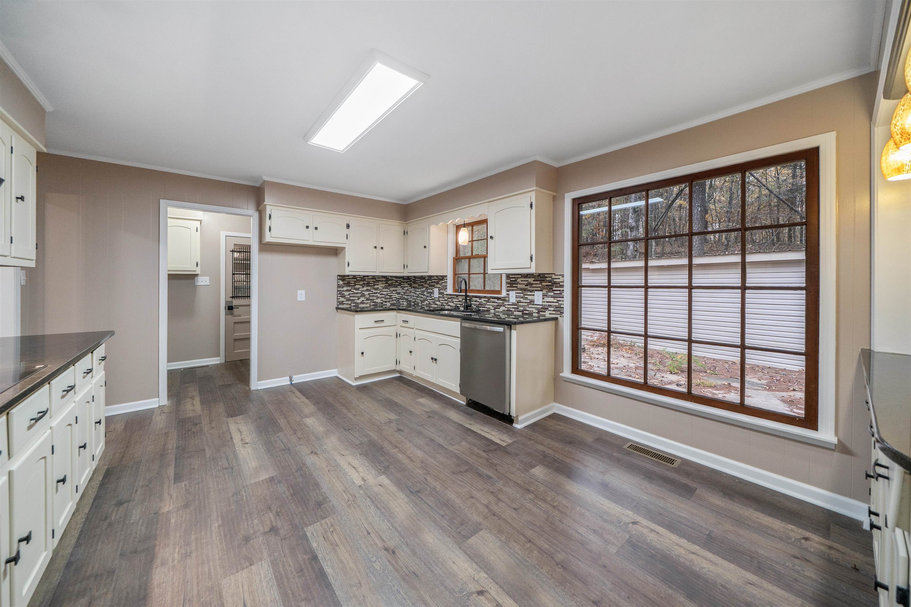 567 South 6th Street Selmer, TN 38375 - Photo 20 of 31 Kitchen with ornamental molding, tasteful backsplash, dishwasher, dark wood-style flooring, and white cabinetry
