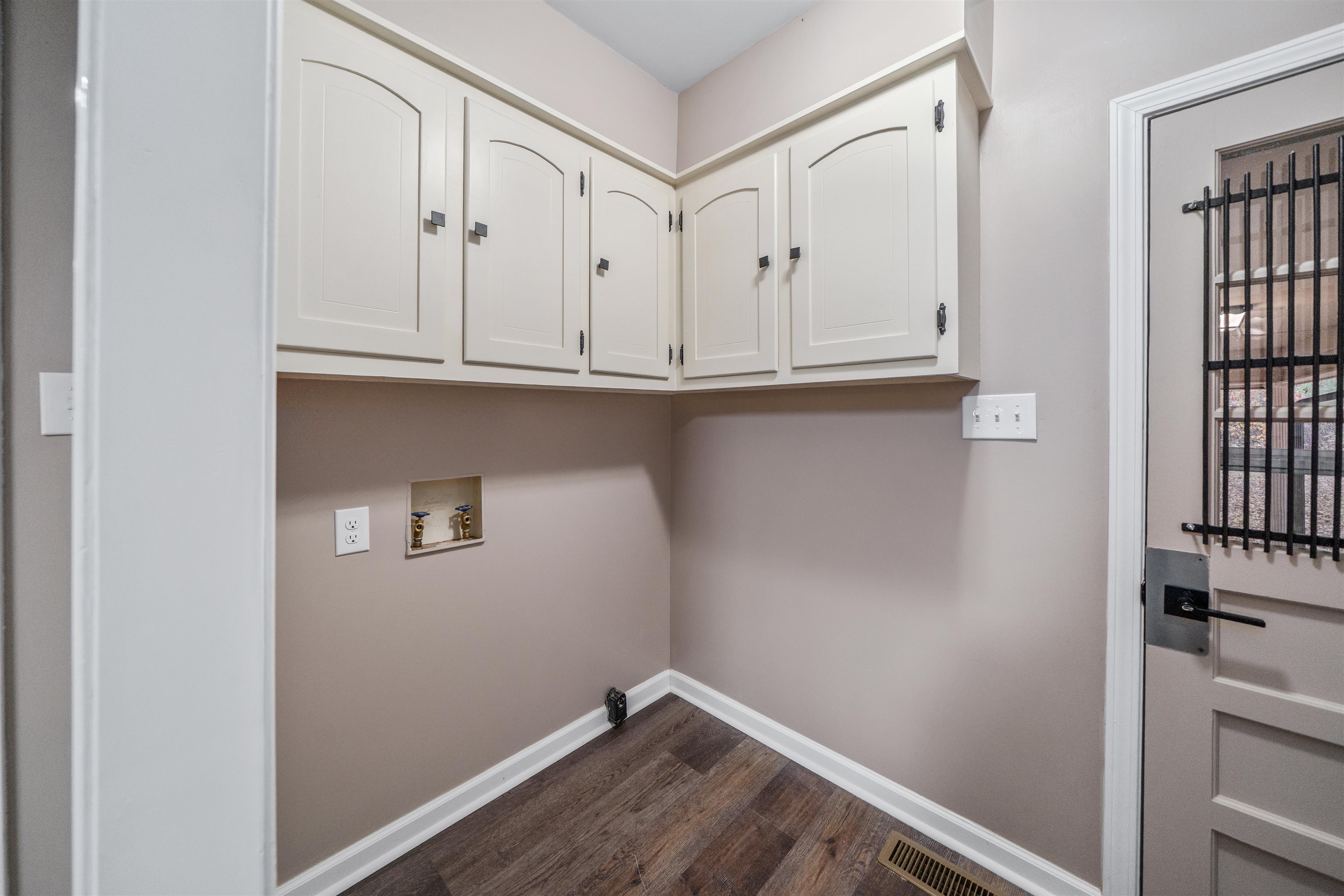 567 South 6th Street Selmer, TN 38375 - Photo 23 of 31 Laundry area featuring washer hookup, dark wood finished floors, and cabinet space