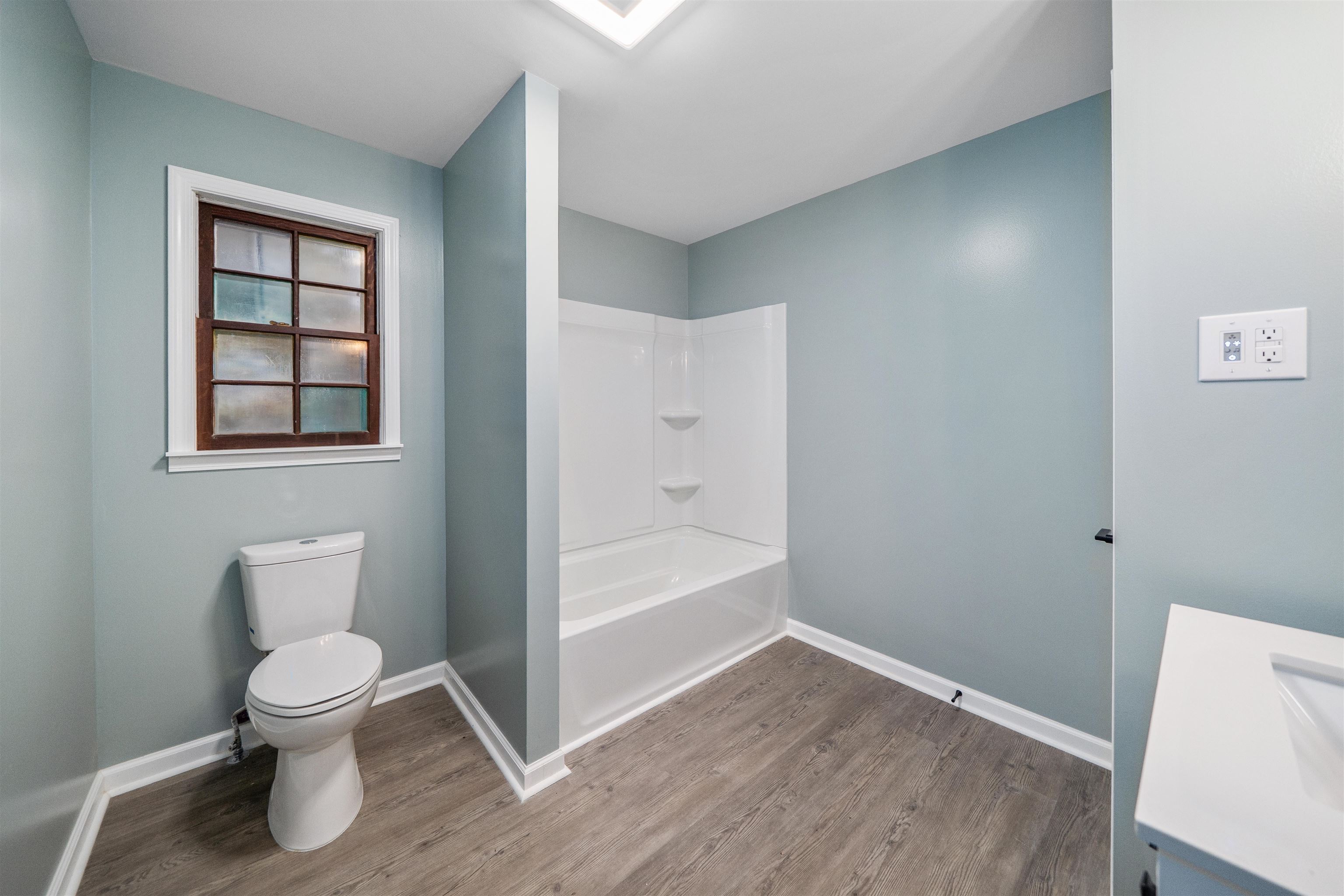 567 South 6th Street Selmer, TN 38375 - Photo 25 of 31 Bathroom with vanity, wood finished floors, and shower / bath combination