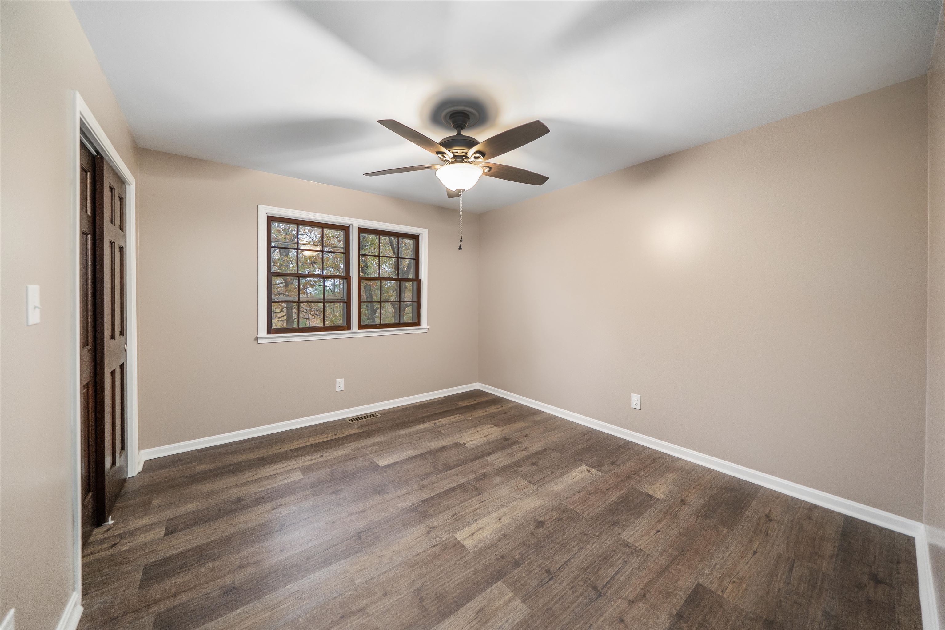 567 South 6th Street Selmer, TN 38375 - Photo 27 of 31 Unfurnished bedroom with a closet, dark wood-style flooring, and a ceiling fan