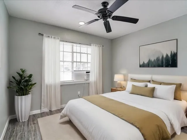a bedroom with a large bed and a chandelier