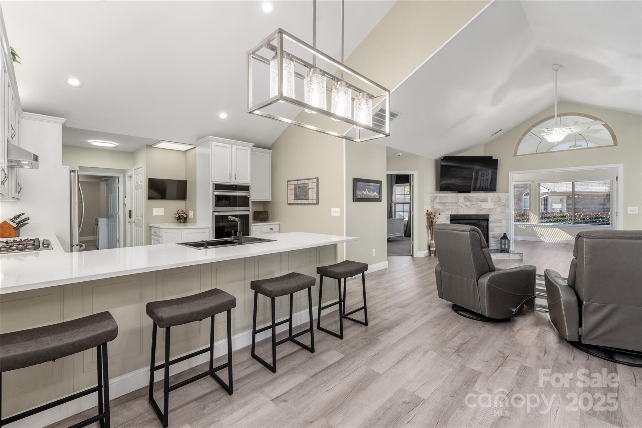 874 Ledgestone Court Tega Cay, SC 29708 - Photo 11 of 38 a large kitchen with cabinets stainless steel appliances a dining table and a chandelier