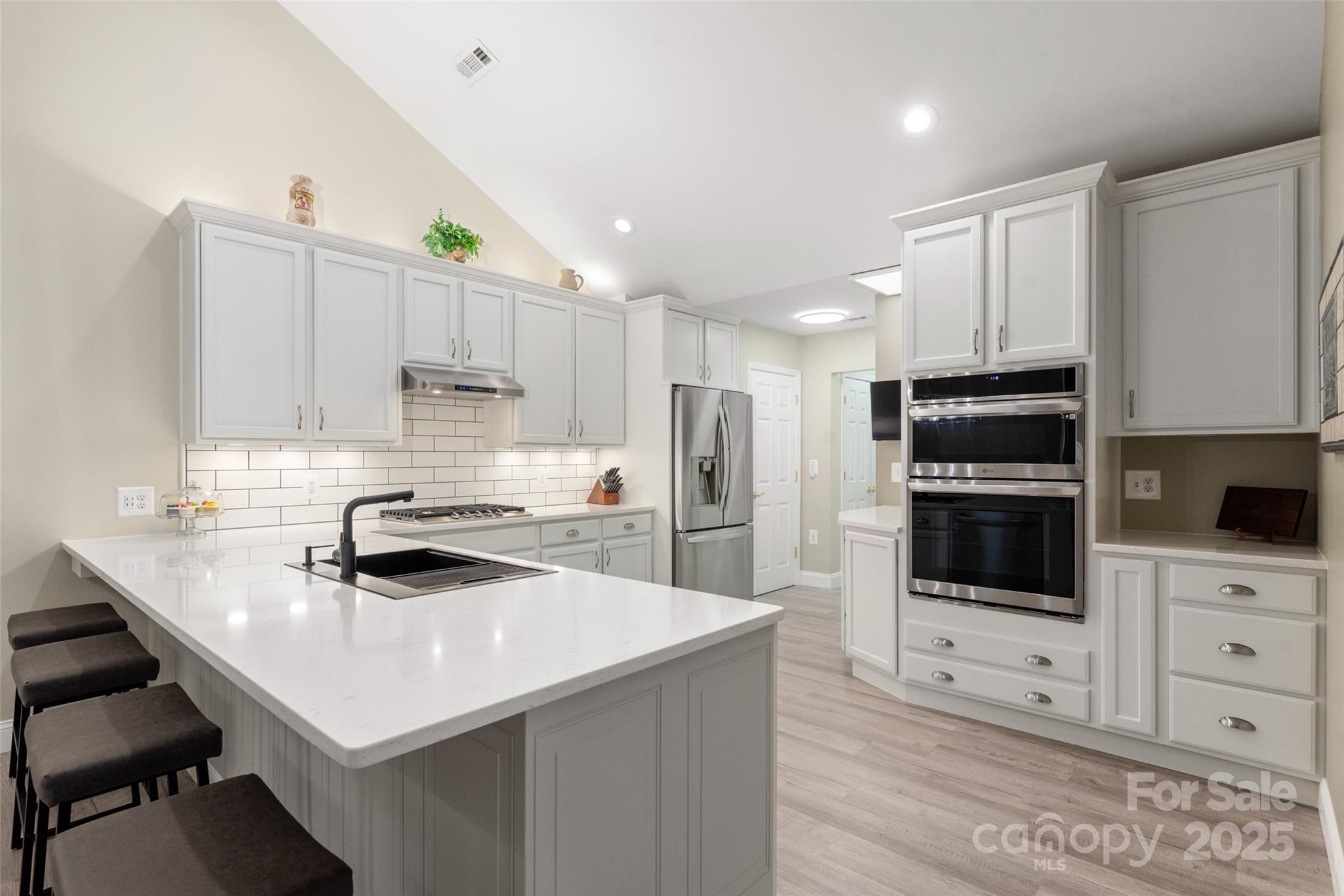 874 Ledgestone Court Tega Cay, SC 29708 - Photo 15 of 38 a kitchen with stainless steel appliances a stove sink microwave and cabinets