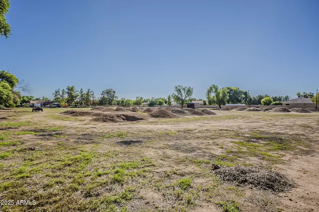 a view of a field with trees in background