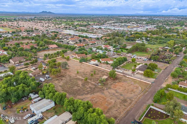 an aerial view of residential houses with outdoor space and trees