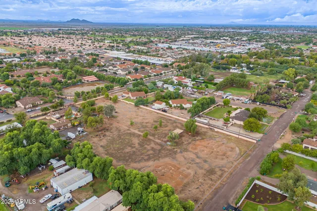 an aerial view of residential houses with outdoor space and trees