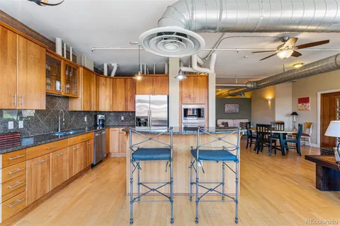 a kitchen with stainless steel appliances kitchen island granite countertop a table and chairs in it