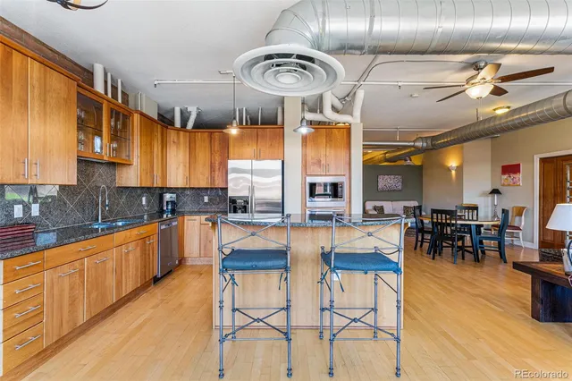 a kitchen with stainless steel appliances kitchen island granite countertop a table and chairs in it