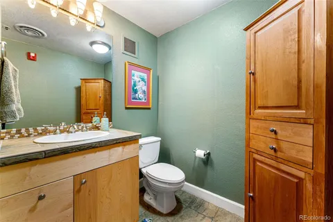 a bathroom with a toilet a sink and mirror