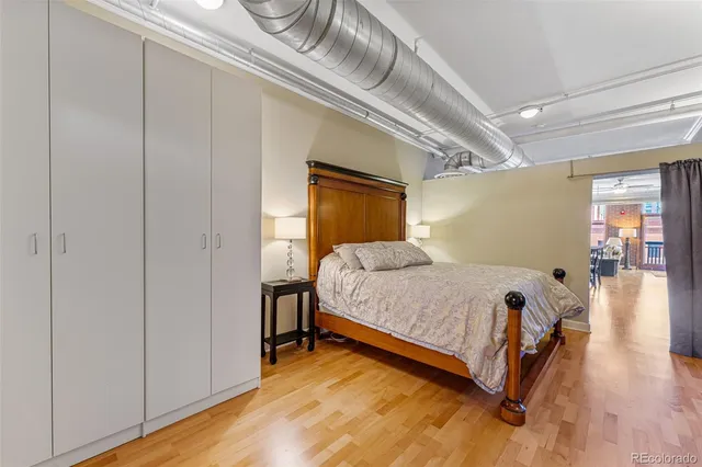 a bedroom with a bed and wooden floor