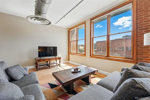 a living room with furniture a flat screen tv and a large window