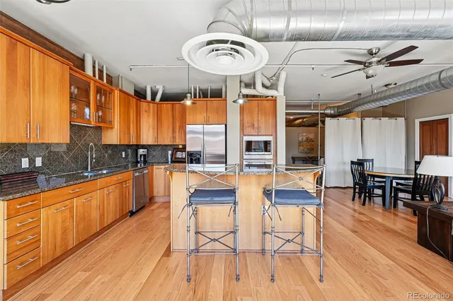 a large kitchen with a large window a counter space and a wooden floor