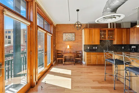 a view of a kitchen with stainless steel appliances granite countertop wooden cabinets a dining table and chairs