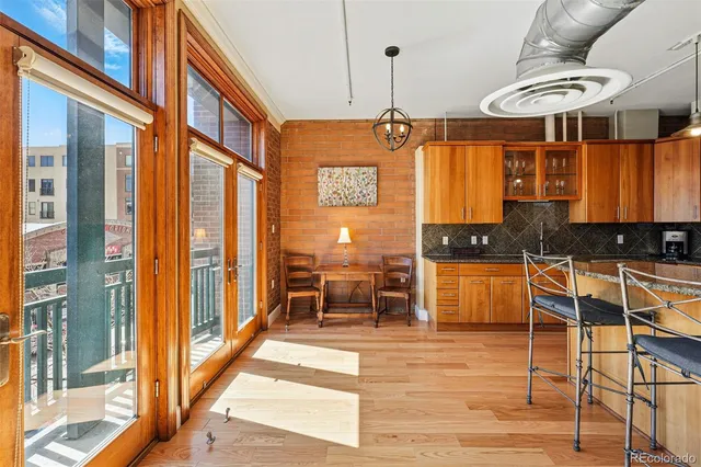 a view of a kitchen with stainless steel appliances granite countertop wooden cabinets a dining table and chairs