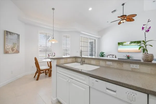 a kitchen with a sink dining table and chairs