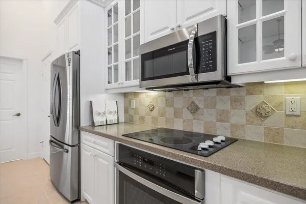 a kitchen with granite countertop cabinets stainless steel appliances and wooden floor