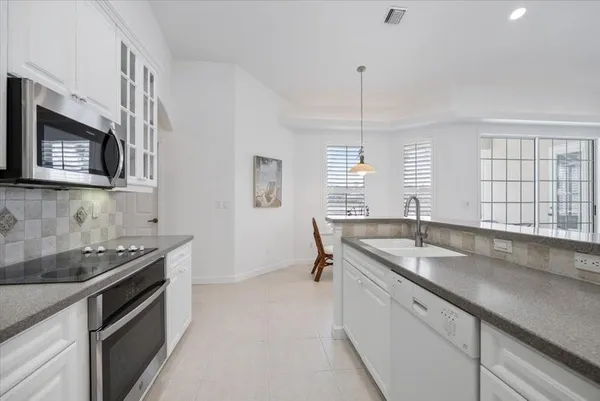 a kitchen with stainless steel appliances granite countertop a sink stove and cabinets
