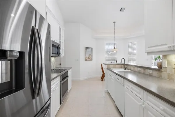 a kitchen with stainless steel appliances granite countertop a sink a stove a refrigerator and island