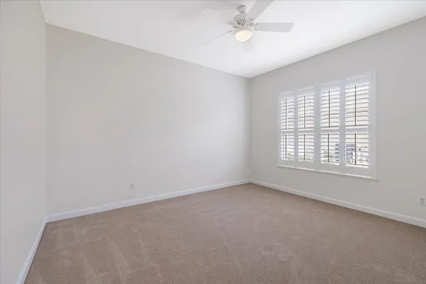 an empty room with a window and a fan
