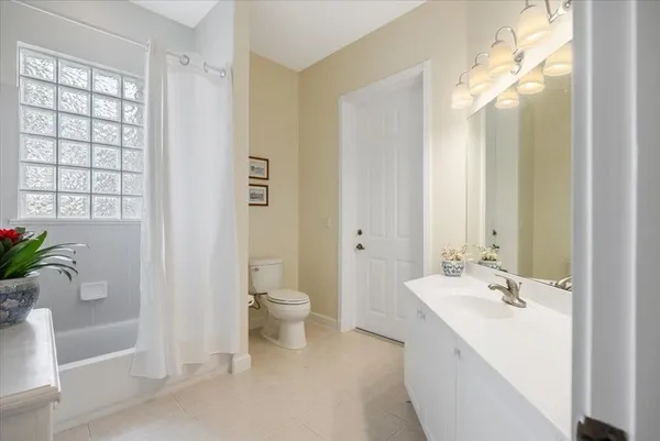a spacious bathroom with a double vanity sink a toilet and a large mirror