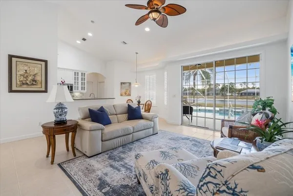 a living room with furniture potted plant and a large window