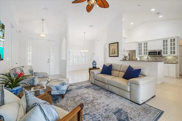 a living room with furniture kitchen view and large windows