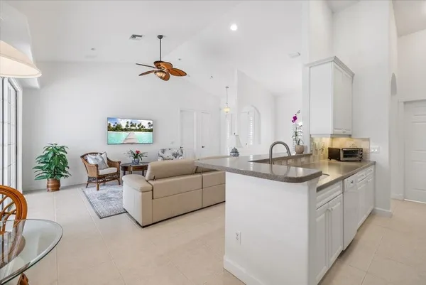 a living room with furniture a sink a window and potted plant