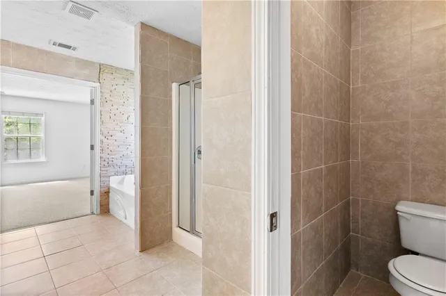 a bathroom with a tub sink shower and two mirror