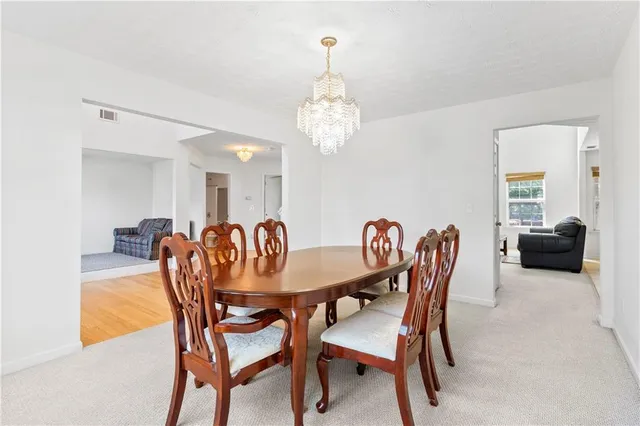 a view of a dining room with furniture and chandelier