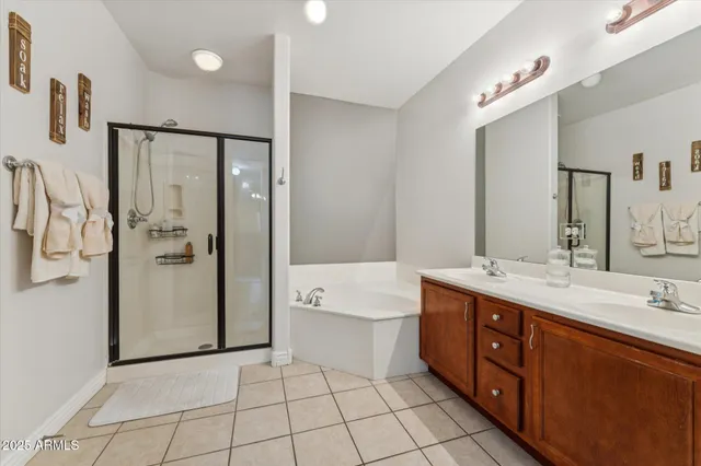 a spacious bathroom with a double vanity sink a mirror and a bathtub