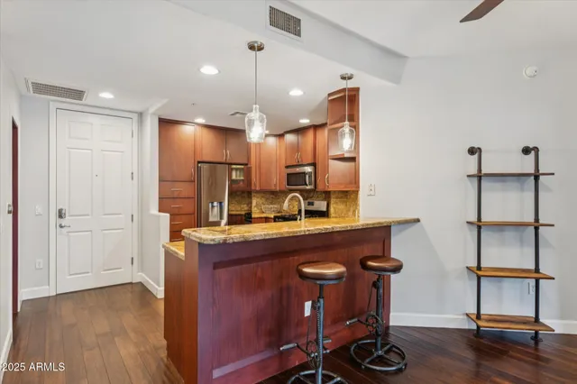 a kitchen with kitchen island a wooden floor and chairs