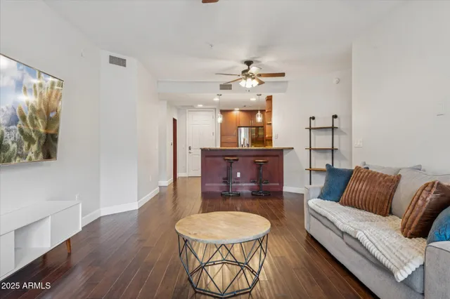 a living room with furniture and a wooden floor