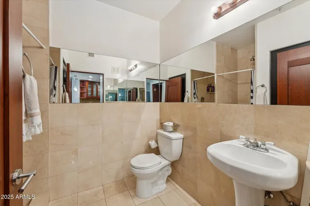 a bathroom with a toilet sink and mirror