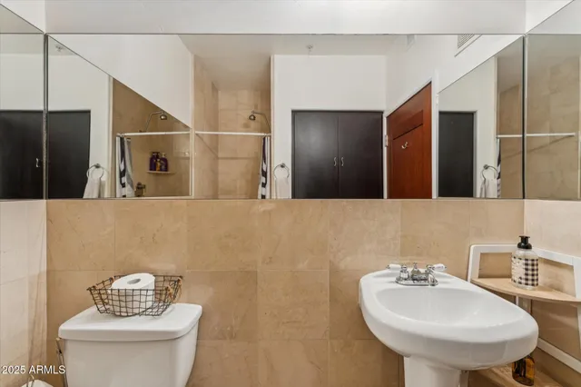 a bathroom with a sink a toilet and a mirror