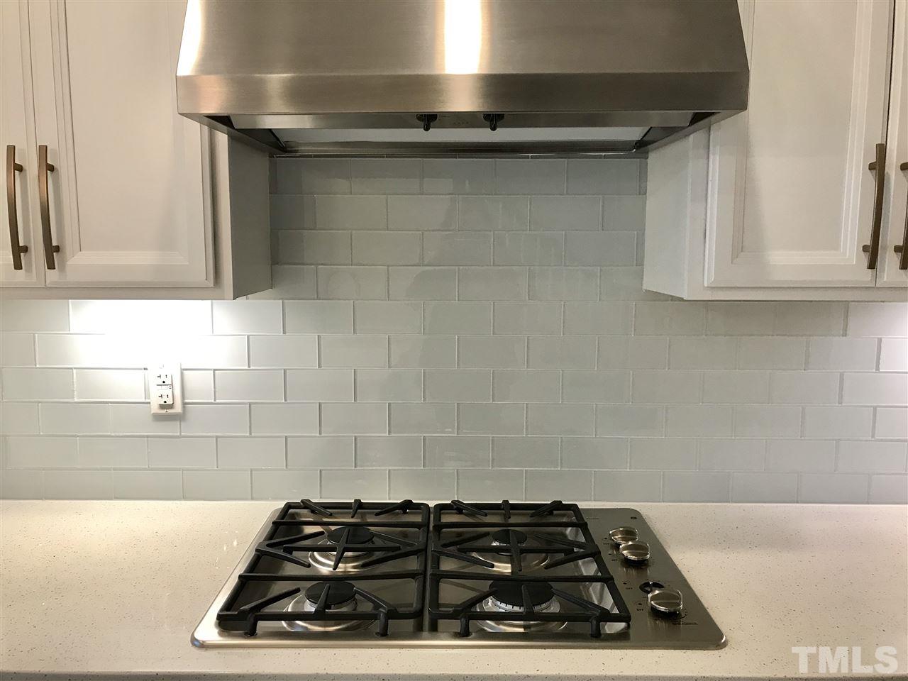 2506 Rambling Creek Road, Unit 32 Apex, NC 27523 - Photo 6 of 30 Gas cooktop, glass backsplash and range hood that vents outside