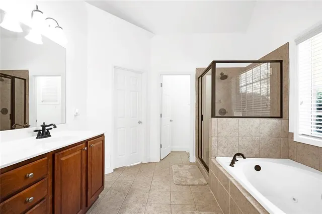 a bathroom with a tub sink and mirror