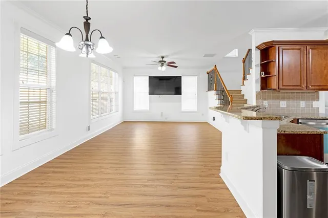 a view of a kitchen with wooden floor and a ceiling fan